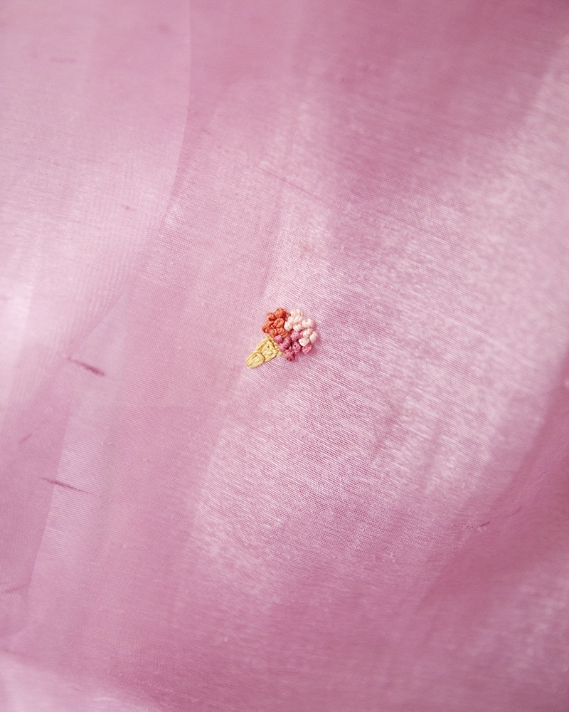 Visible mending med broderi – kreativ reparation af tøj Synlig reparation med broderet isvaffel på lyserød stof.