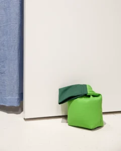 Grøn genbrugsdørstopper Grøn dørstopper holder en hvid dør åben.