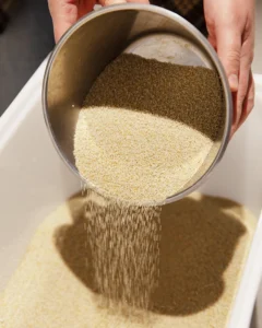 Genbrug af kalkpellets En skål med kalkpellets hældes ud i en beholder.