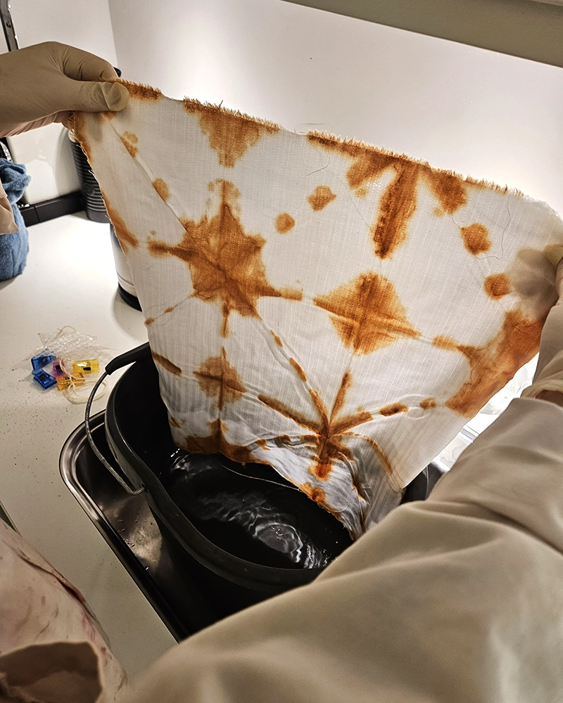 Okkerfarvning af tekstiler Okkerpigment og genbrugstekstiler klar til farvning
